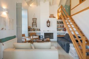 a living room with a blue couch and a staircase at Spetses Estia Orloff in Spetses