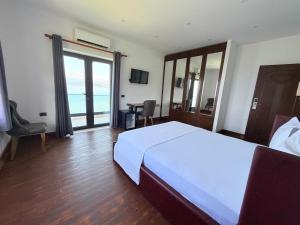 a bedroom with a bed and a view of the ocean at Hotel Victoria in Pogradec