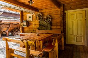 a wooden dining room with a wooden table and chairs at Močiutės sodyba in Latežeris