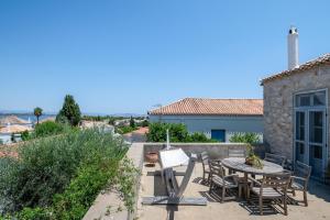 a patio with a table and chairs and a building at Spetses Estia Orloff in Spetses