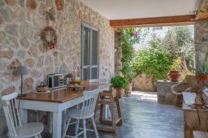a kitchen with a table and chairs in a stone wall at Spetses Estia Orloff in Spetses