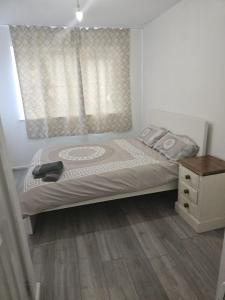 a bedroom with a bed and a dresser and a window at 2bdr Ground Floor Flat in Edmonton free Parking and WiFi in Ponders End +2 photos
