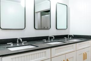a bathroom with three sinks and two mirrors at Cache House in Jackson +24 photos