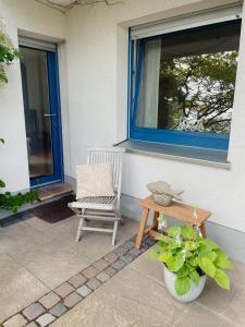 a bench and a chair on a porch with a window at Ferien in der Flurstraße in Velbert