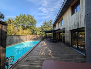 a house with a swimming pool and a wooden deck at Villa Mammouth in Saint Alban Auriolles +48 photos