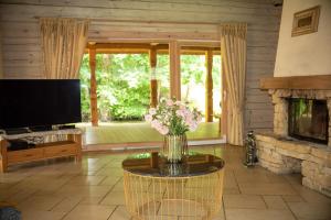 a living room with a fireplace and a vase of flowers at Močiutės sodyba in Latežeris