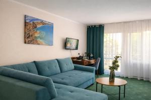 a living room with a blue couch and a table at Trojak Mysłowice in Mysłowice