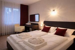a bedroom with a large white bed with red pillows at Trojak Mysłowice in Mysłowice