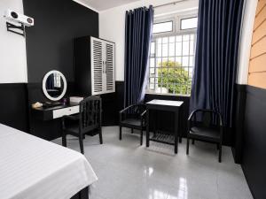 a bedroom with a bed and a desk and a mirror at The Luxe Homestay in Buôn Ðũng +83 photos