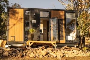 a tiny house sitting on top of a pile of rocks at Black Snake Sky Box by Tiny Away in Grantow
