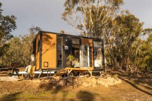 a tiny house sitting on top of a pile of rocks at Black Snake Sky Box by Tiny Away in Grantow