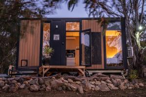 a tiny house sits on a pile of rocks at Black Snake Sky Box by Tiny Away in Grantow +29 photos