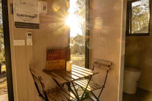 a table and chairs with a candle on a wall at Black Snake Sky Box by Tiny Away in Grantow