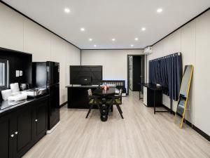 a room with a table and a television in it at The Luxe Homestay in Buôn Ðũng
