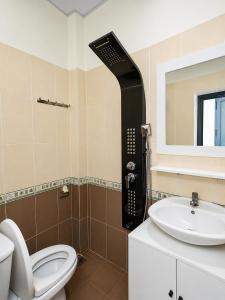 a bathroom with a toilet and a sink at The Luxe Homestay in Buôn Ðũng