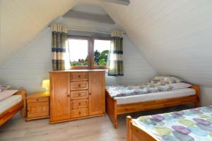 a attic room with two beds and a window at AchKaszuby domki nad morzem in Puck