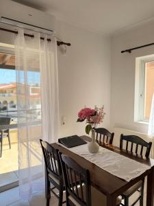 a dining room table with a vase of flowers on it at Kanelli΄s apartments in Monemvasia