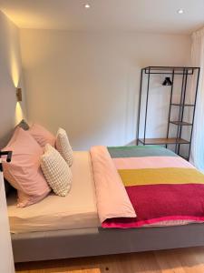 a bed with a colorful blanket and pillows at Lieblingsbude Homberge in Ennepetal