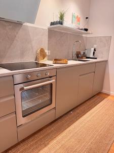 a kitchen with a stainless steel stove and a sink at Lieblingsbude Homberge in Ennepetal