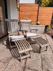 two wooden chairs sitting next to each other on a patio at Lieblingsbude Homberge in Ennepetal