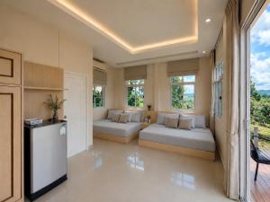 a large living room with two beds and windows at Phuyafahsai The Resort Khao Kho in Khao Kho