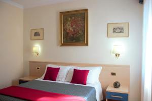 een slaapkamer met een bed met rode en witte kussens bij Città Eterna Guest House in Rome
