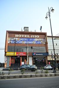 a building with a car parked in front of it at Hotel Jiio in Kurukshetra