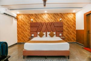 a bedroom with a bed with a wooden wall at Hotel Jiio in Kurukshetra