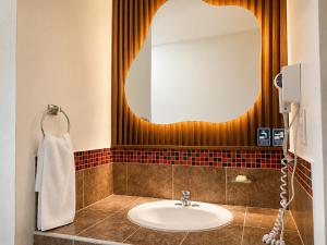 a bathroom with a sink and a mirror at Vista Zacatlan Hotel in Zacatlán