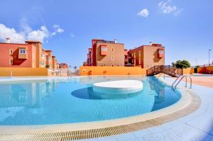 a large swimming pool with buildings in the background at Salitre y lava in Corralejo