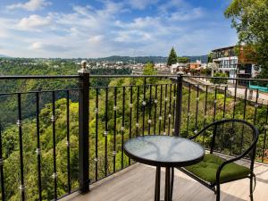 a table and chair on a balcony with a view at Vista Zacatlan Hotel in Zacatlán