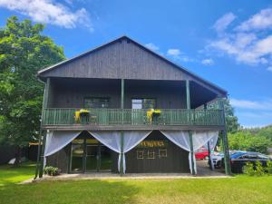 a barn with a balcony and flowers on it at Hotel Mergera in Mērsrags