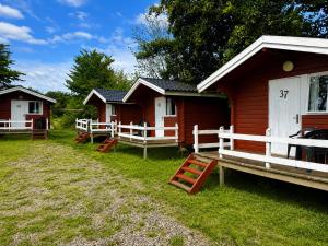 a group of cottages with red and white at Rudbøl Naturcamping in Højer