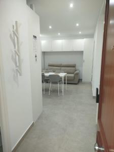 a room with a couch and a table and chairs at Aires de Chipiona Apartamento B in Chipiona +2 photos