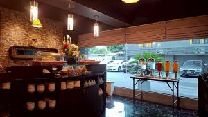 a restaurant with a counter with drinks and a window at Sweetloft Hotel Don Muang in Bangkok