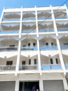 a white building with windows and a person standing outside at Tchaopremium in Lomé