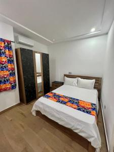 a bedroom with a bed with a colorful blanket on it at Tchaopremium in Lomé +12 photos