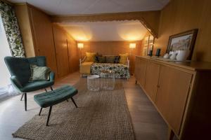 a hotel room with a bed and a green chair at Capanna in Wildhaus