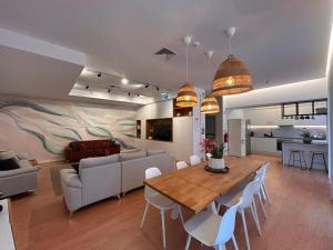 a dining room and living room with a table and chairs at Pedra de Sal Hostel & Suites in Rio Maior