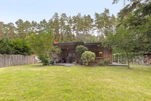 a wooden house in a backyard with a yard at Urlaubsoase am Bruchsee in Templin