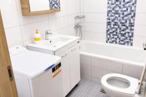 a white bathroom with a sink and a toilet at Elli's House - Apartment in Lixouri