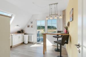 a kitchen and dining room with a table and chairs at Fewo Tief Blick in Dornum