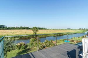 a balcony with a view of a river at Fewo Tief Blick in Dornum