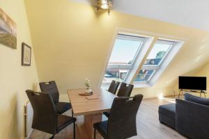 a dining room with a table and chairs at Fewo Tief Blick in Dornum