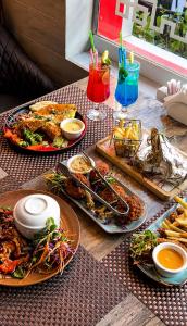 a table with plates of food and drinks on it at Hotel Haven Lahore in Lahore