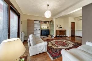 a living room with a white couch and a tv at Suite La perla degli Iblei in Giarratana