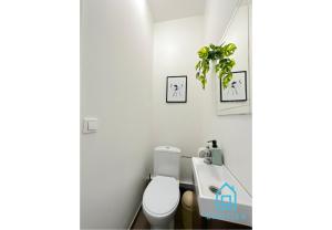 a bathroom with a toilet and a plant on the wall at Seaside Room in Gdynia