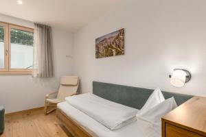a living room with a couch and a chair at Residence Diana Apartment 401 in Terento