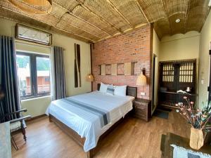 a bedroom with a bed and a brick wall at Tam Coc Sweet Home in Ninh Binh +85 photos
