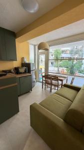eine Küche und ein Wohnzimmer mit Sofa und Tisch in der Unterkunft Petrus in Rafailovici